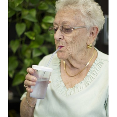 Ältere Dame trinkt aus dem Sip-Tip Trinkbecher.